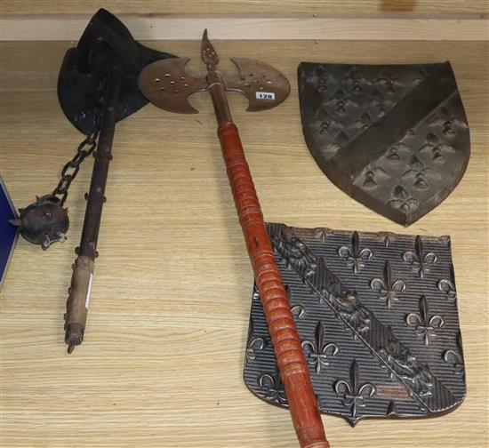 A collection of stage weapons and two shield shaped metal panels